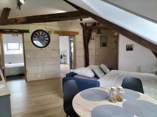 Habitación con sofá, mesa y reloj en Brume de Loire en Bourgueil