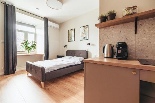 een kleine slaapkamer met een bed en een keuken bij Przytulny apartament przy dworcu in Radom