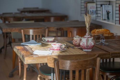 une table en bois avec des tasses et des soucoupes, dans l'établissement chateau haut gouat, à Vertheuil-en-Médoc