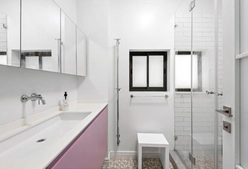 a white bathroom with a sink and a shower at Modern 2BR Private House Neve Tsedek by HolyGuest in Tel Aviv