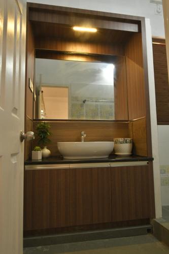 a bathroom with a sink and a mirror at Gloria Homestay ,Thrissur in Trichūr