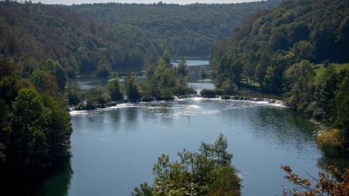 an aerial view of a river in a forest at MREŽNICA - ZELENA BAJKa in Generalski Stol