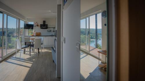 a kitchen and dining room with a view of a balcony at MREŽNICA - ZELENA BAJKa in Generalski Stol
