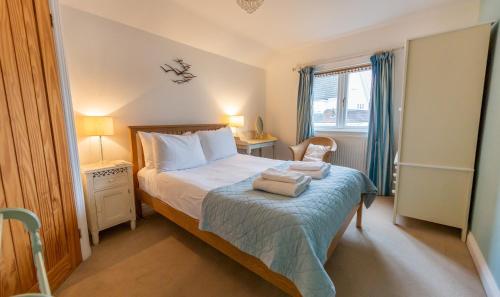ein Schlafzimmer mit einem Bett mit zwei Handtüchern darauf in der Unterkunft Wherry Cottage, Sleeps 8 in Southwold