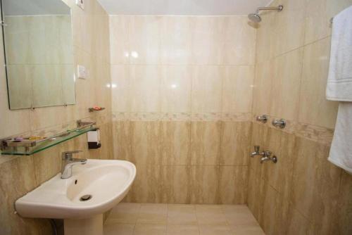W łazience znajduje się umywalka i prysznic. w obiekcie Central Inn & Spa w mieście Dhaka