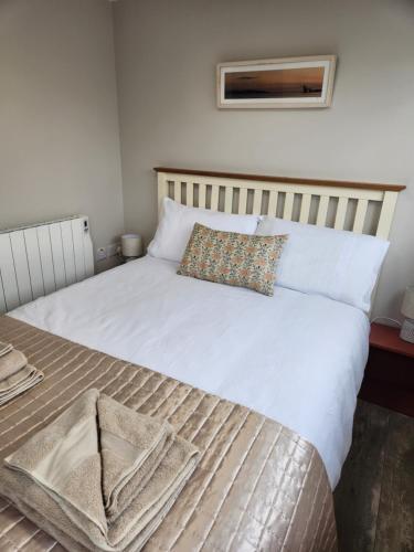 Una cama con sábanas blancas y una almohada. en Atlantic Way Urban Escape en Galway