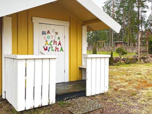 a white and yellow house with a sign on the door at 4 star holiday home in Mönsterås-By Traum in Mönsterås