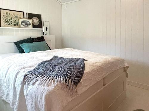 a white bedroom with a bed with a blue pillow at 4 star holiday home in Mönsterås-By Traum in Mönsterås