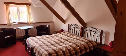 a bedroom with a bed and a table and a window at Rezidence Lipka in Králíky