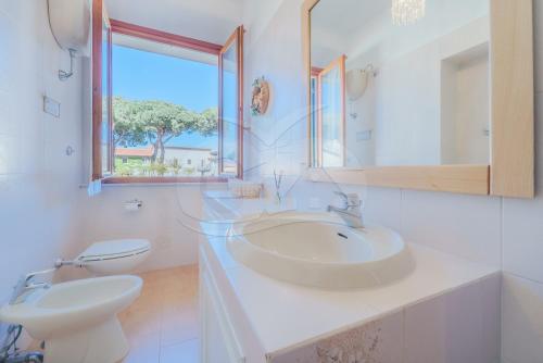 a bathroom with a sink and a toilet and a window at Casa Federica - Goelba in Marciana Marina