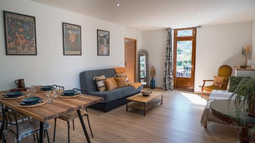 sala de estar con sofá y mesa en L'appart - Les Lodges de Praly, en Les Ollières-sur-Eyrieux