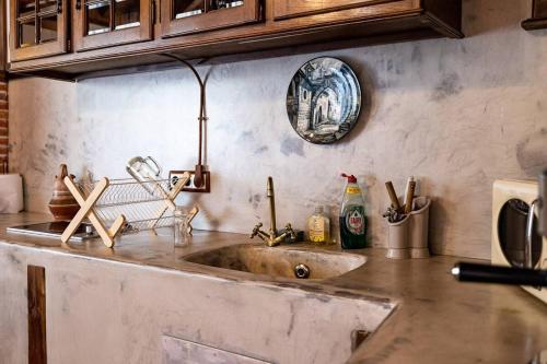 um balcão de cozinha com um lavatório e um prato na parede em Villa Micaela em Lamadrid