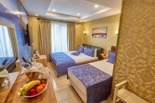 a hotel room with two beds and a bowl of fruit on a table at Ardey Hotel in Istanbul