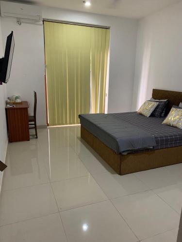 a bedroom with a bed and a sliding glass door at R&R residencies in Mount Lavinia