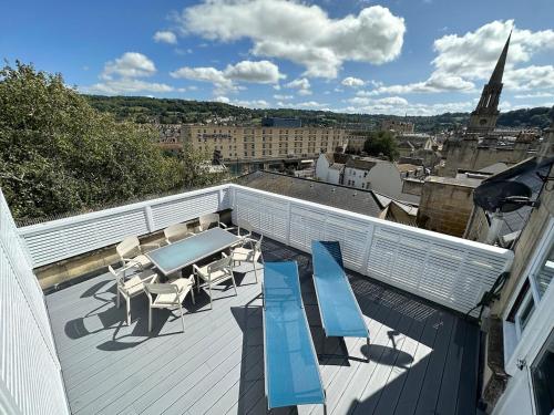 a balcony with a table and chairs on a roof at The Roof Terrace Maisonette - City Centre in Bath