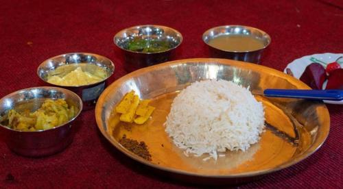 a bowl of rice and other food on a table at The Ridge Homestay in Suryodaya