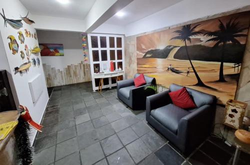 a living room with two couches and a painting on the wall at Pousada Beijos y Abraços in Natal