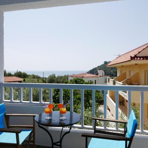 a balcony with a table and two drinks on it at Limnionas Bay Village Hotel in Marathokampos
