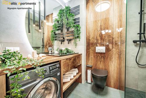 a bathroom with a washing machine and a sink at Baltic Apartments - Matejki 17 in Świnoujście