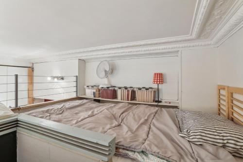 Charmant appartement en plein coeur du Marais في باريس: سرير كبير في غرفة ذات سقف