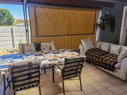 a living room with a table and a couch at Swaeltjie in Somerset West
