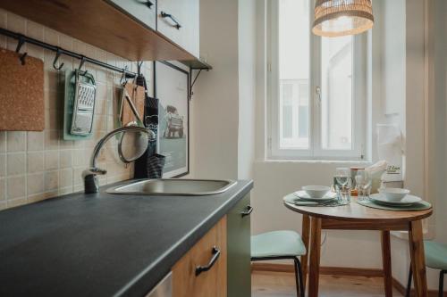 cocina con fregadero y mesa pequeña en Una casa a San Giacomo x2, en Trieste