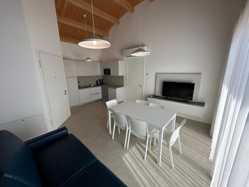 a living room with a white table and chairs at Woody Green Penthouse Sea View - Agenzia Cocal in Caorle