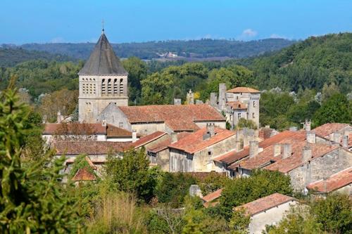 un groupe de bâtiments et une église dans une ville dans l'établissement Cadre idyllique sur 1ha de parc, en centre de village - Classé par la Fondation de France, à Mareuil-sur-Belle