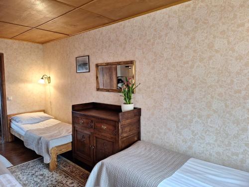 a bedroom with two beds and a dresser with a mirror at Kraavi Guest Hostel in Kuressaare