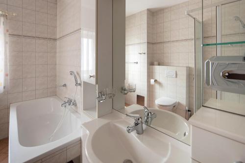 y baño con lavabo, bañera y aseo. en Workers Castle Apartments für die besten Monteure en Sankt Michael in Obersteiermark