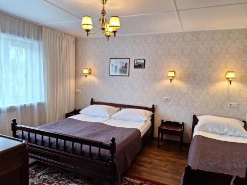 a bedroom with two beds and two lights on the wall at Kraavi Guest Hostel in Kuressaare