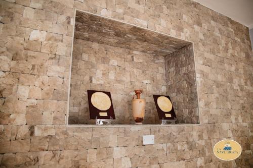 a stone wall with two vases on a shelf at Le Dimore di Ulisse a Gela - Casa vacanza B&B - La nave greca in Gela