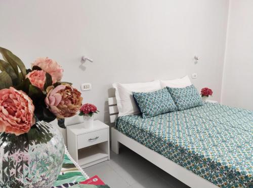 - une chambre avec un lit et un vase avec des fleurs dans l'établissement Villa Calipso - Appartamento in Villa con giardino e wi-fi, à Ovile la Marinella