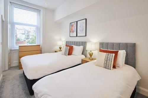 two beds in a room with white walls and a window at Host & Stay - Seaview Retreat in Whitby