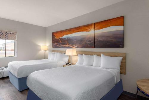 a hotel room with two beds and two lamps at Days Inn & Suites by Wyndham Tucson/Marana in Tucson