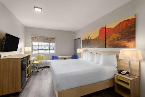 Habitación de hotel con cama, escritorio y TV. en Days Inn & Suites by Wyndham Tucson/Marana, en Tucson