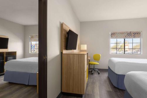 a room with two beds and a flat screen tv at Days Inn & Suites by Wyndham Tucson/Marana in Tucson