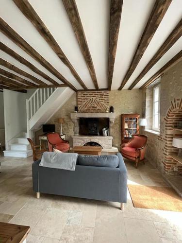 sala de estar con sofá azul y chimenea en La Tibourdière : au coeur du pays des châteaux, maison au calme entre vignes et champ, en Cheverny
