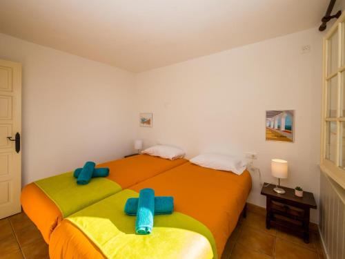 2 camas en una habitación con sábanas azules y amarillas en Villa Boreal, en Calonge