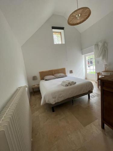 1 dormitorio blanco con 1 cama y ventilador en La Tibourdière : au coeur du pays des châteaux, maison au calme entre vignes et champ, en Cheverny