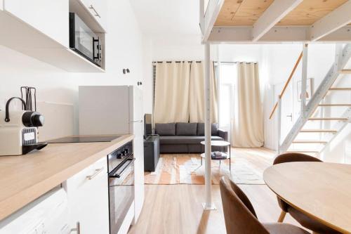 une cuisine et un salon avec une table et un canapé dans l'établissement Lille Bel appartement Cosy avec Mezzanine, à Lille