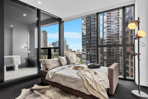 a bedroom with a bed and a large window at A Comfy Apt Only a 5-min Walk to Victoria Market in Melbourne