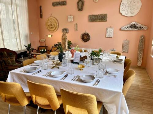 a dining room with a white table and chairs at Maison Georges in Tourcoing