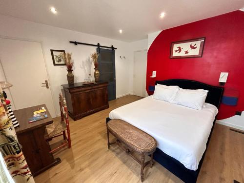 a bedroom with a bed with a red wall at Maison Georges in Tourcoing