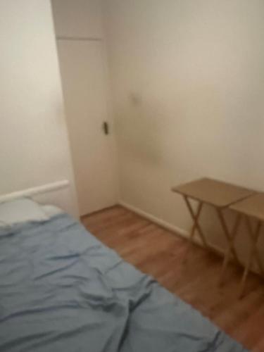 ein Schlafzimmer mit einem Bett und einem Tisch darin in der Unterkunft Affordable Room to Rent for Short Stay in Abbey Wood