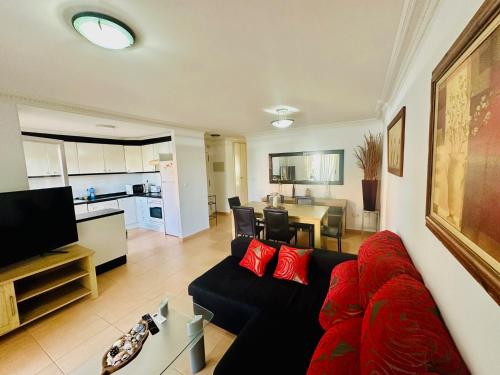 Il comprend un salon avec un canapé rouge et une cuisine. dans l'établissement Punta me Beautifull apartment near the beach Les Marines, à Dénia