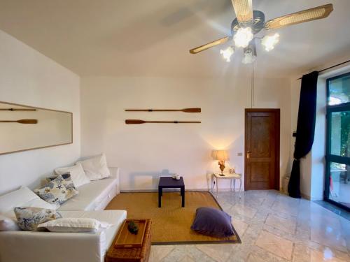 a living room with a white couch and a ceiling fan at Casa vacanza comoda con vista in Bosa