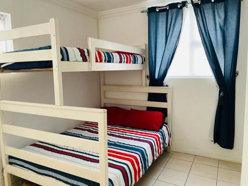 a bedroom with two bunk beds and a window at Mariette's Cottage in Arniston