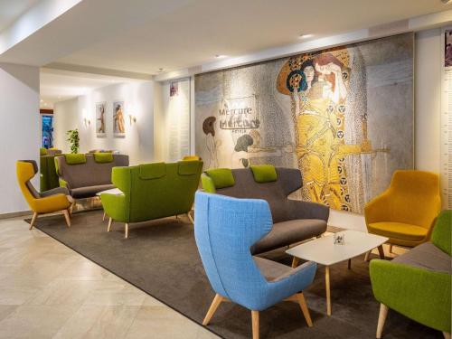 a waiting room with colorful chairs and tables at Hotel Mercure Wien Westbahnhof in Vienna