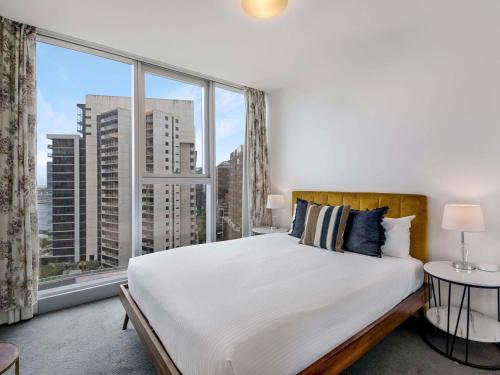 The Sebel Residences Melbourne Docklands Serviced Apartments في ملبورن: غرفة نوم بسرير كبير ونافذة كبيرة